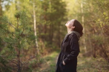 Doğa parkında yürüyen ve temiz hava soluyan bir kız. Nefes alma, nefes alma, rahatlama konsepti.