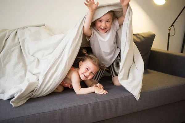 happy children at home play on sofa bed. kids fun.