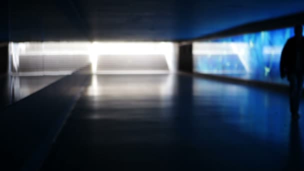 Niebieski oświetlony tunel, metro - ludzie chodzą przez — Wideo stockowe