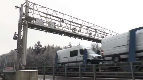 Camiones pasan un pórtico de control del sistema de peaje de camiones alemanes — Vídeo de stock