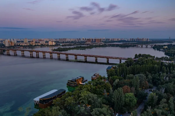 Akşam Kiev 'i kuş bakışı gördüm. Mimari anıtlar. Fenerlerin ve gece lambalarının ışığı. Dinyeper 'daki şehir. Beyaz binalar. Gün batımı.
