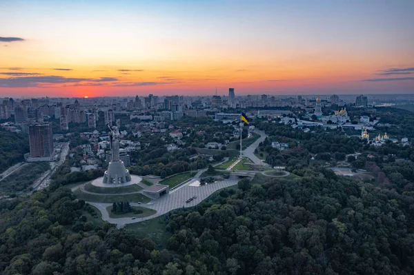Anavatanı Kiev 'de akşam gökyüzünün arka planına karşı kuş bakışı bir anıt. Akşam Kiev ve şehrin ana abidesi. Ve batan güneşe ve yakıp kavuran ateşe..
