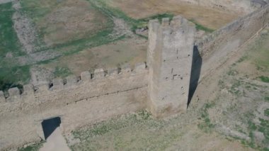 Kuşbakışı Belgorod-Dnestrovskaya kalesi. Ukrayna 'nın en büyük kalesi Dinyester Nehri üzerindedir. Yeşil çiçekli su ve kalenin beyaz taş duvarları.