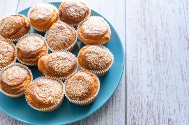 Ev yapımı mısır ekmeği çöreklerini ahşap kırsal masa arka planında mavi tabakta fotokopi alanı ile yakın çekim yap.