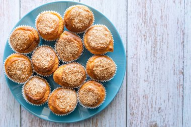 Ev yapımı mısır ekmeği çöreklerini ahşap kırsal masa arka planında mavi tabakta fotokopi alanı ile yakın çekim yap.