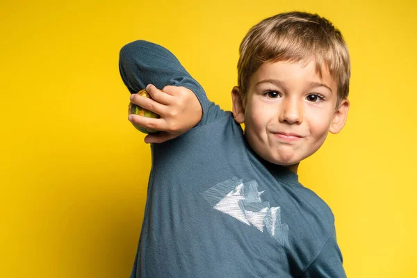 Portrait of happy joyful small caucasian boy in front of yellow background making faces - Childhood growing up and achievement concept - front view waist up copy space