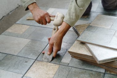 Balkona ya da terasa seramik fayansları yerleştirmek için çekiç kullanan tanınmamış usta zanaatkârların ellerini yapıştırın - inşaat endüstrisi konsepti fotokopi alanı