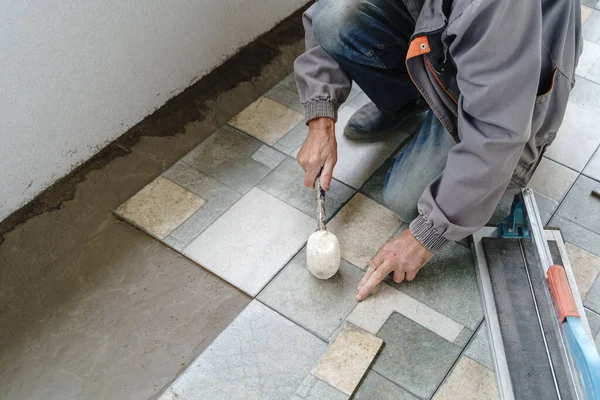 Balkona ya da terasa seramik fayansları yerleştirmek için çekiç kullanan tanınmamış usta zanaatkârların ellerini yapıştırın - inşaat endüstrisi konsepti fotokopi alanı