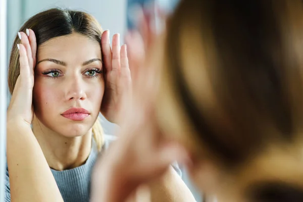 Young adult caucasian woman doing face yoga gymnastics for non-surgical rejuvenation and self-care - anti aging concept