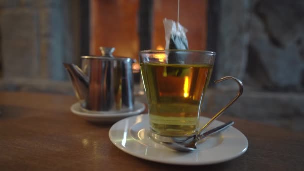 靠近屋前壁炉前的一杯草茶 热饮料和女用手袋 — 图库视频影像