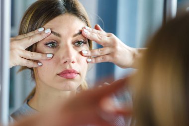 Genç beyaz kadın cerrahi olmayan gençleştirme ve kendi kendine bakım için yoga jimnastiğiyle karşı karşıya. Yaşlanma karşıtı konsept.