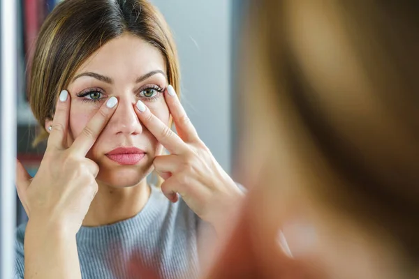 Young adult caucasian woman doing face yoga gymnastics for non-surgical rejuvenation and self-care - anti aging concept