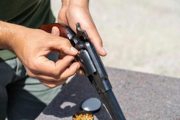 Close up on hand of unknown man loading Old black powder Percussion Army Revolver vintage gun replica Civil War Old wild west style