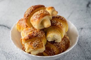 Ev yapımı peynirli kruvasanları mermer masadaki seramik kaseye koy. Kahvaltıda ev yapımı atıştırmalıklar. Organik sağlıklı geleneksel Sırp yemekleri.