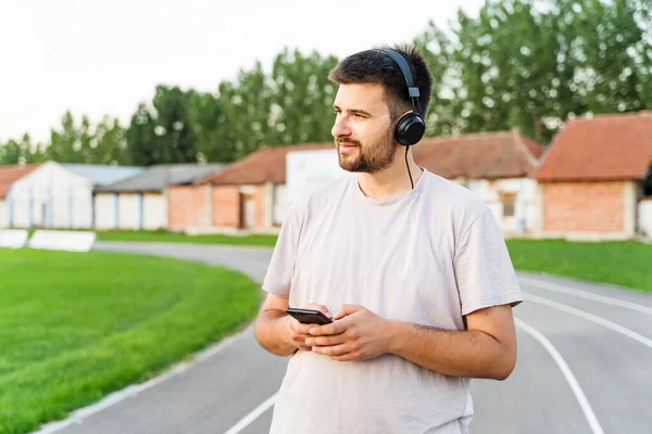 Hombre Pie Pista Atletismo Día Con Teléfono Inteligente Los Auriculares — Foto de Stock