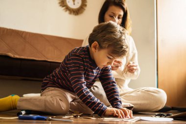 Evde oynayan anne ve oğul, sanatsal ve sanatsal oyuncaklar yaparak eğleniyorlar. Yetenekler geliştiriyorlar. Çocukluk ve gelişim, yeni beceri yaratıcılık kavramı.