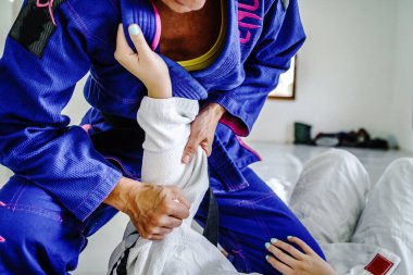 Brezilya jiu jitsu bjj ya da judo eğitiminde iki bayan sporcunun dövüş tekniklerini çalıştırması nefsi müdafaa için kimono gisini tutan ileri düzey korumalar.
