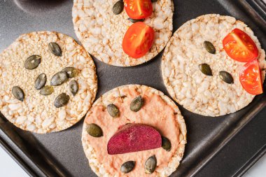 Masada gevrek pirinç kekleri domates ve pancar sebzeleri ve masada susam kabağı tohumları - sağlıklı vejetaryen ya da vejetaryen olmayan glütensiz kahvaltı üzerine üst görüş