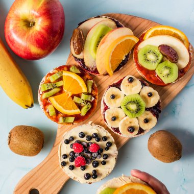 Taze meyveli, kivili, muzlu, ahududu ve portakallı pirinç kekleri masada. Sağlıklı organik vejetaryen ya da vejetaryen kahvaltısı glütensiz.