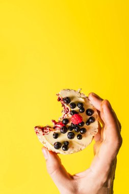 Sarı arka planda taze meyve böğürtlenli gevrek pirinç keki. Sağlıklı organik vejetaryen ya da vegan kahvaltısı glütensiz fotokopi alanı.