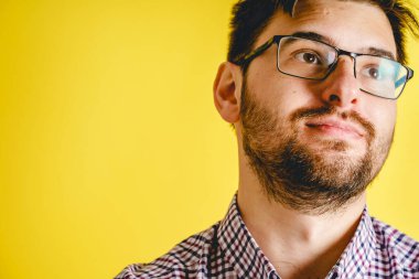 Modern sarı arka planda gözlüklü yetişkin beyaz adamın ön görüntüsü. Yan tarafa bakıyor. Uzayı kopyala.