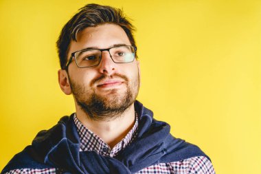 Modern sarı arka planda gözlüklü yetişkin beyaz adamın ön görüntüsü. Yan tarafa bakıyor. Uzayı kopyala.