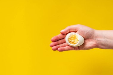Sarı arka planda yumurta sarısı olan haşlanmış yumurtaya yaklaş.