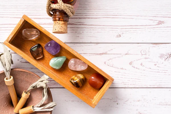 Yedi çakranın yukarıdan aşağı görüntüsü zihin ve ruh için kristal taşları iyileştiriyor. Reiki, ahşap masada fotokopi alanı ile alternatif tıp uyguluyor.
