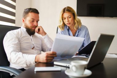 Beyaz erkek ve kadın büroda proje belgelerine bakıyor raporları veya sözleşmeleri inceliyor - erkek ve kadın iş arkadaşları devam eden proje hakkında düşünüyor - iş ve yönetim kavramı