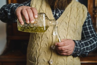 Geleneksel Sırp Bosnalı Hırvat ya da Maceralı içki içen, alkollü brandy rakija ya da evde özel cam kokans erikli slivovitza içen bir adamın ellerine yaklaş.