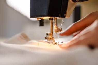 Elektrikli dikiş makinesine dikiş diken tanımadığım bir kadının ellerine yaklaş.