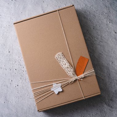 Masanın üzerindeki karton kutuda el yapımı hediyeyi kapat.