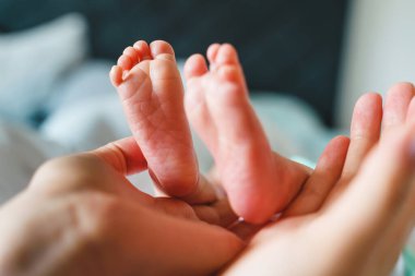 Gün içinde yeni doğmuş bebeğinin ya da kızının ayaklarını tutan kimliği belirsiz bir kadının ellerine yaklaş. Annelik ve annelik aşkı mekanı kopyalama kavramı.