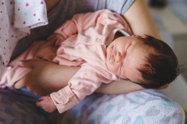 Yeni doğmuş bebeğini kucağında iki hafta tutan kimliği belirsiz, beyaz bir kadın. Kucağında annesinin kollarında uyuyan ya da şekerleme yapan bir kız. Çocukluğu büyüyüp ebeveynlik kavramı.