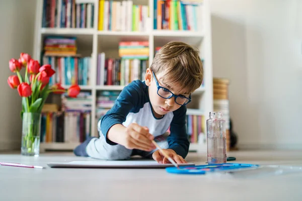 4歳の白人男の子の家で床で遊ぶフロントビュー 小さな子供は絵筆を使用しながら水彩画を描くコンセプトレジャーや創造的な教育を成長させる芸術スキルを開発 — ストック写真