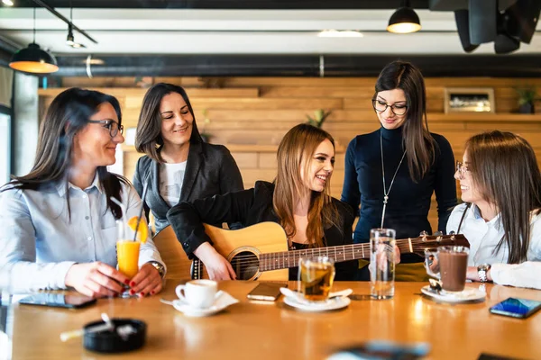 Genç Milenyum Kadınları Kafeteryada Restoranda Oturmuş Gitar Çalarak Eğlenirken Şarkı — Stok fotoğraf
