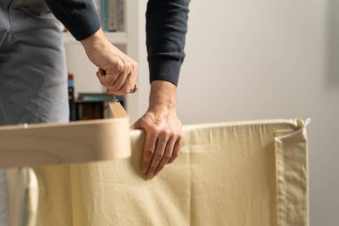 Kimliği belirsiz beyaz bir adamın evdeki mobilyaların montaj koltuğunu vidaladığını gördüm.