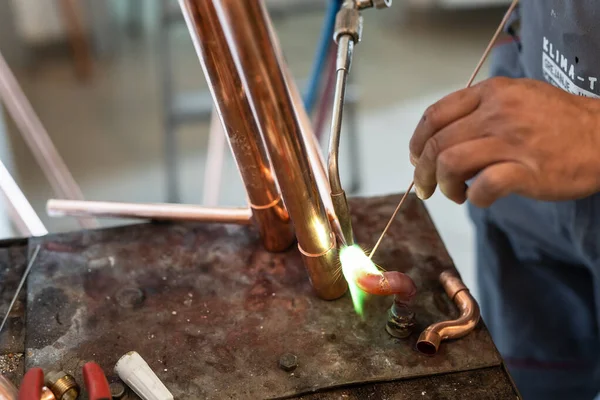 İşyerinde gaz lambası ya da kaynak makinesi kullanan merkezi ısıtma boruları olan bilinmeyen endüstriyel tesisatçıların ellerini kapatın.