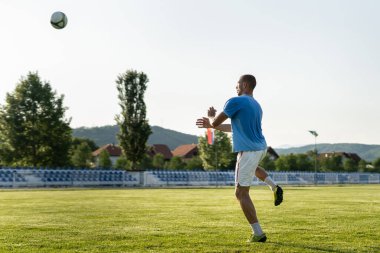 Tam boy futbol oyuncusu maç veya antrenman başlığında topa vuruyor
