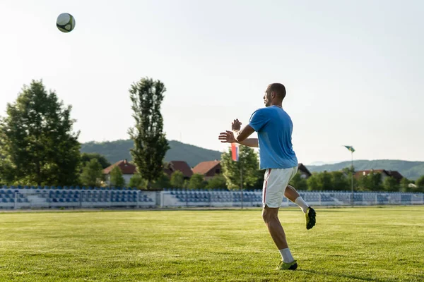 フル長さのサッカー選手は試合やトレーニングヘッダーでボールを蹴る — ストック写真