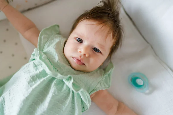 Vista Superior Niña Pequeña Cama Cuna Casa Durante Día Mirando — Foto de Stock