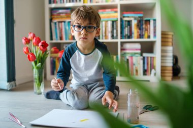 Evinde yerde oynayan dört yaşındaki beyaz bir çocuk hakkında ön görüş - suluboya resim yaparken boya kullanan küçük bir çocuk sanatsal beceriler geliştiriyor, eğlence ve yaratıcı eğitim geliştiriyor.