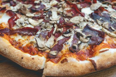 Evdeki ya da restorandaki masada dilimlenmiş pizzaya yaklaş.