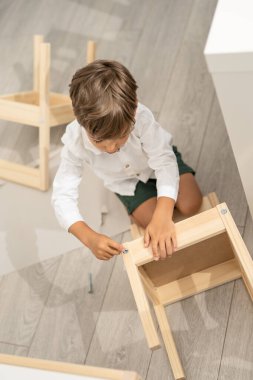 Kafkasyalı küçük bir çocuk, dört yaşında. Gün içinde kendini montajlayan sandalyeyle ya da evde masada oynuyor. Küçük çocuk, tek başına mobilya montajlıyor.