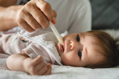 Dört aylık küçük bir beyaz bebeğe yaklaşın ve kimliği belirsiz bir babanın evde ebeveynlik yaparken ona antibiyotik vermesi ve sağlık sorunları olan sıvı uyuşturucu ağız şırıngası konseptini uygulayın.