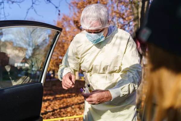 身穿防护服的医疗技术人员从坐在车上的病人身上采集血液样本 以检测Covid Coronavirus Delta变异体流行病的概念 — 图库照片