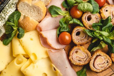 Taze kesilmiş peynire yaklaş. Tuğlaları masaya koy. Aperatifin üzerindeki yemek parçaları.