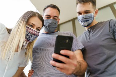 Cep telefonu kullanan beyaz erkek ve kadının yan görüntüsü - Modern iletişim çevrimiçi mesajlaşma - Maskeli kadın ve erkekler cep telefonlarını - sosyal mesafeler yeni normal kavram
