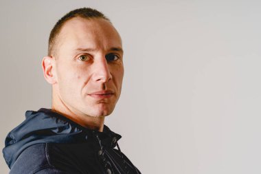 Beyaz arka planda fotokopi alanı olan ciddi bir beyaz adamın portresi.