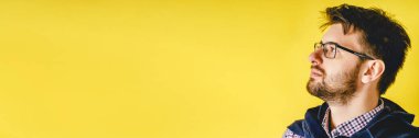 Modern sarı arka planda gözlüklü yetişkin beyaz adamın yan görünüşü - fotokopi alanını kapatın